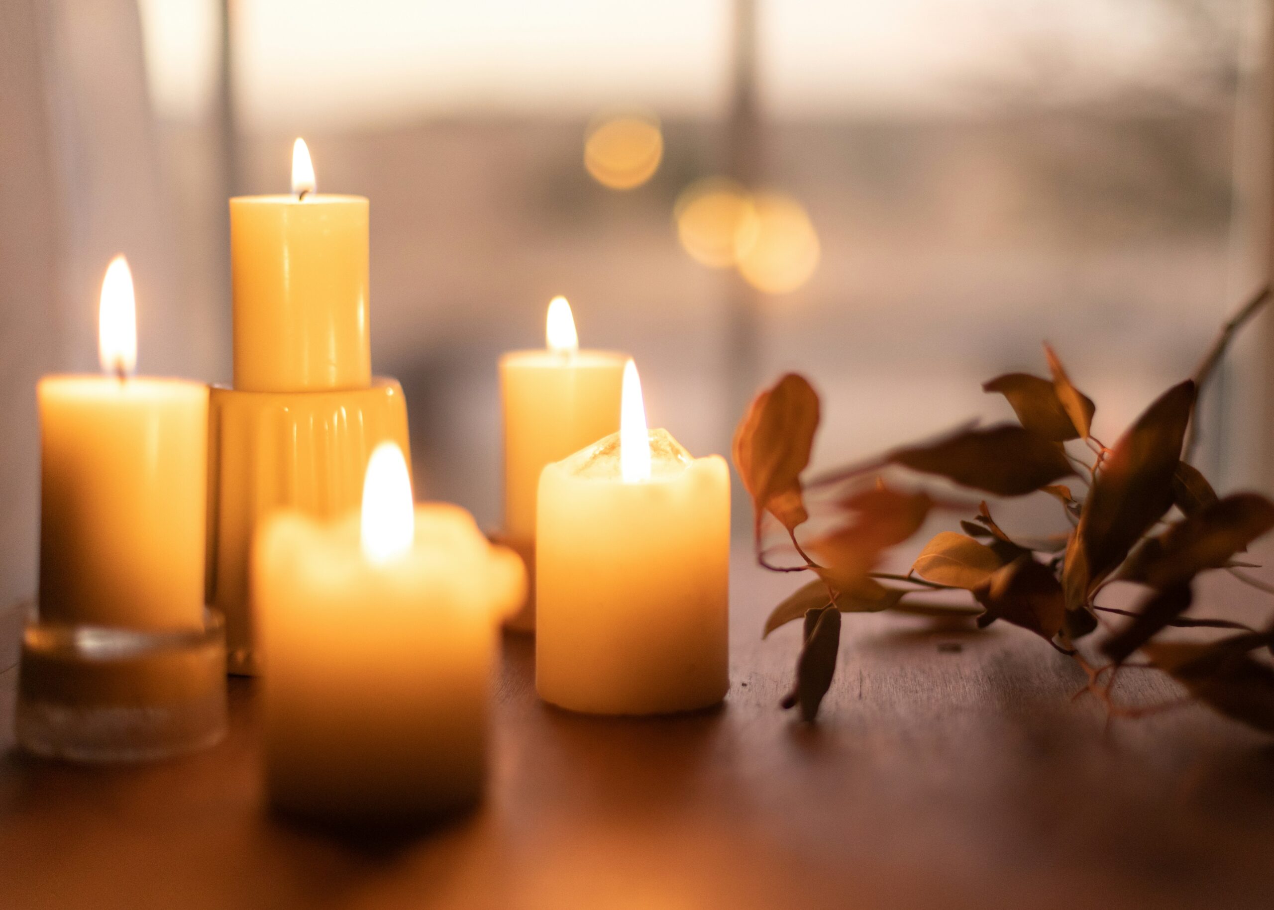Bougies blanches sur table en bois clair — ambiance de recueillement